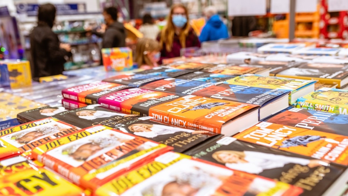 a table full of children's books with people in the background