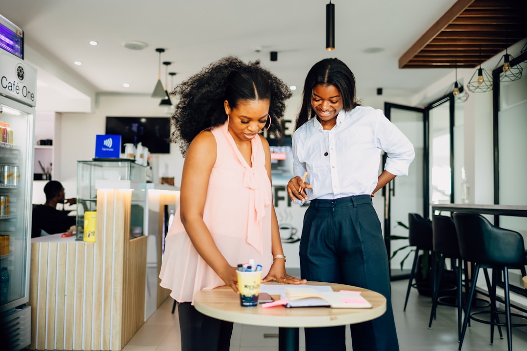 A couple of women standing next to a table