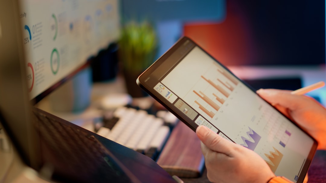 Someone analyzes financial data on a tablet.