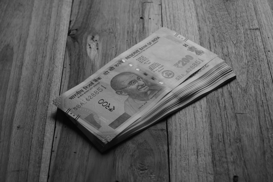 A stack of indian rupees on wood.