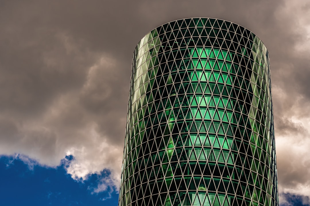 A modern building stands tall against a cloudy sky.