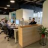 a group of people sitting at desks in an office