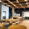 A modern cafe with wooden tables and ceiling.