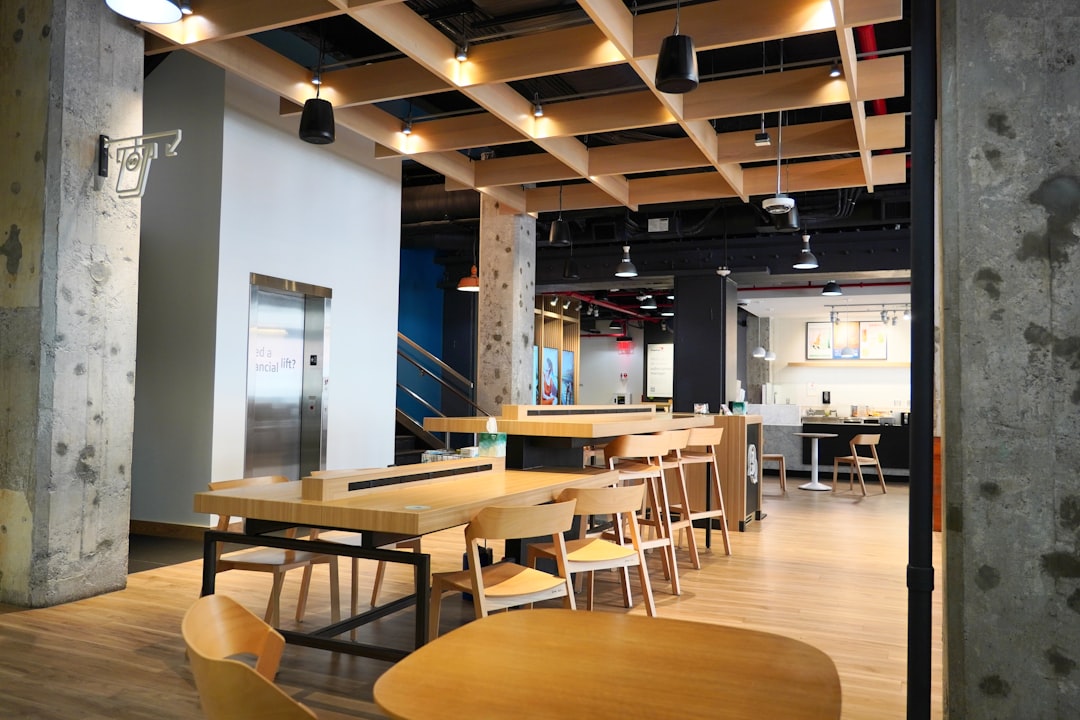 A modern cafe with wooden tables and ceiling.