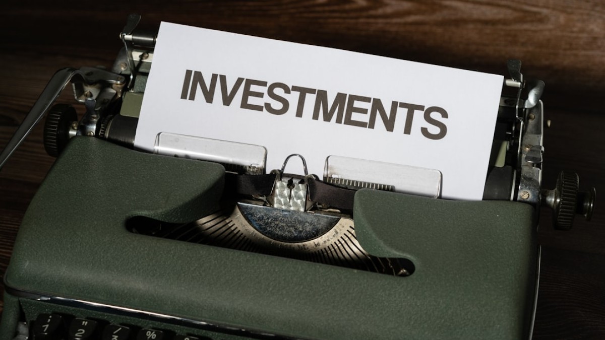 a close up of a typewriter with a paper that reads investments